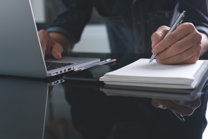 business man writing in notebook